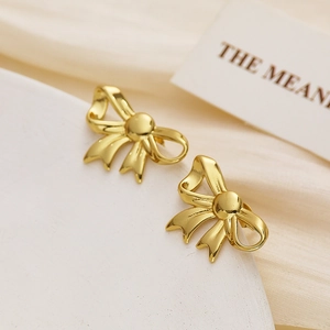 Detailed view of gold bow-shaped earrings with a polished finish and elegant design