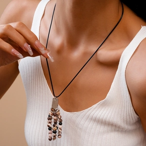 Ethnic vintage beaded tassel necklace with brown and black beads on black cord chain