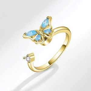 Rotating golden butterfly open ring with blue gemstone and white pearl detail