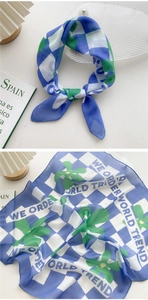 Detail of blue checkerboard scarf with green floral print and translucent texture