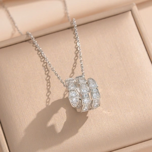 Macro shot of silver snake-shaped necklace with layered rhinestones in a gift box