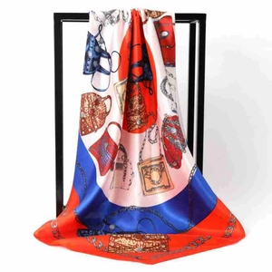 Detail of red and blue satin silk square scarf featuring handbag and chain patterns