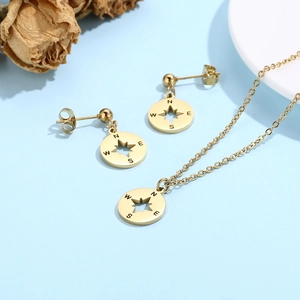Détail d'un ensemble de bijoux boussole dorés avec pendentif étoile et boucles d'oreilles