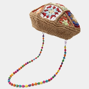 Détail de fleurs au crochet et perles en bois colorées sur le béret en maille bohème