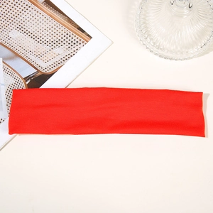 Detailed close-up of a vibrant red moisture-wicking sports headband on a white background