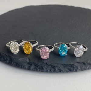 Macro detail of oval cut gemstones in yellow, pink, and blue on encrusted S925 silver rings