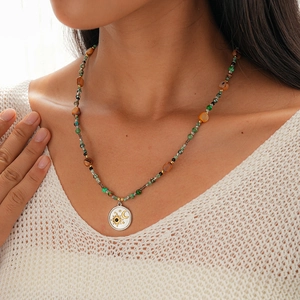 Detail of bohemian necklace with colorful stone beads and silver sun and moon pendant