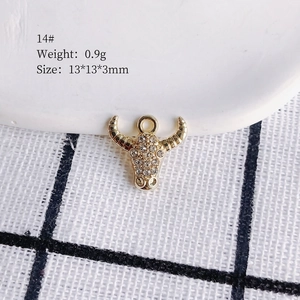 Close-up of golden ox head pendant with inlaid crystals and precise size measurements