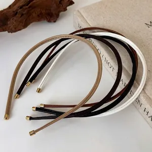 Minimalist leather headband set with gold metal tips in four earth-tone colors