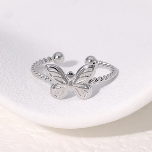 Bague papillon argentée avec texture torsadée et anneau ajustable sur céramique