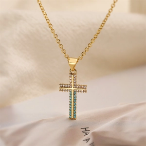 Macro detail of gold cross pendant with turquoise stones and white cubic zirconia crystals