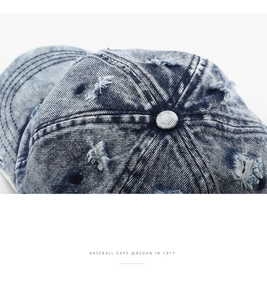 Dettaglio ravvicinato del cappellino in denim blu lavato con trama del tessuto e cuciture