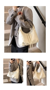 Detail of off-white oversized soft leather hobo bag with drawstring fringe on stairs