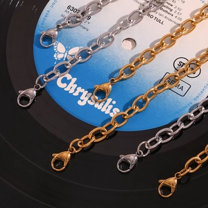 Detailed macro of gold and silver stainless steel chains with lobster clasps on vinyl