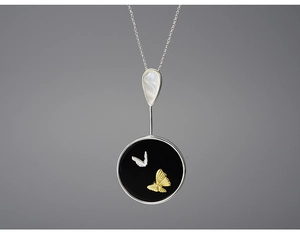 Detail of elegant butterfly pendant with mother of pearl inlay and black circular base