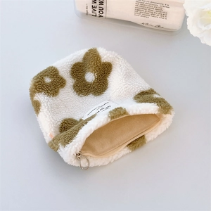 Close-up of a plush floral coin purse with a soft cream texture and zipper detail