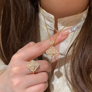 Golden clover jewelry set with necklace and ring featuring pearls and zircon accents