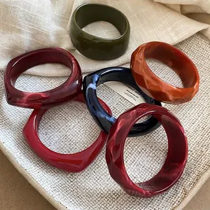 Group of multifaceted acrylic resin bangles in retro colors on an elegant tray