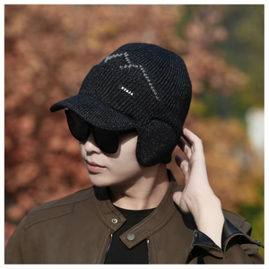 Detailed side view of winter knit trapper hat with visor and grey mountain texture