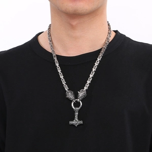 Detailed close-up of Mjölnir pendant with Viking wolf heads on a braided steel chain