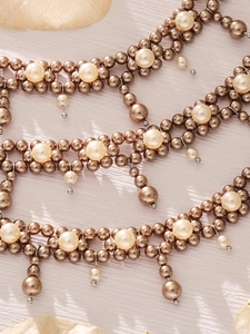 Detailed view of handmade grey pearl beads and vintage tassel pendant on the steel bracelet