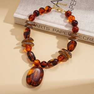 Retro amber beaded necklace with irregular geometric pendant on vintage background