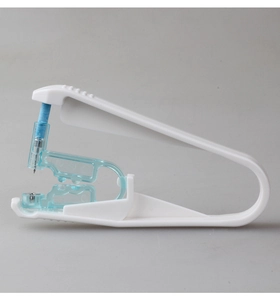 Close-up of disposable ear piercing gun with white plastic handle and blue needle buckle