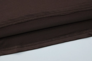 Detail of double-needle stitching on the dark brown pleated dress with elastic fabric