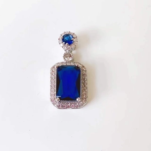 Detailed view of rectangle blue stone pendant with white diamonds in silver setting