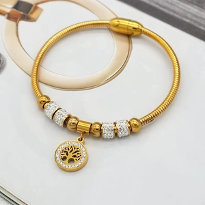 Gros plan du bracelet chaîne serpent doré avec pendentif arbre de vie et zircons