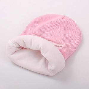 Détail du bonnet en tricot rose avec doublure en polaire blanche et texture