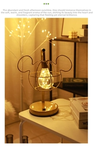 Close-up of golden mouse head metal frame with LED filament bulb on a round base