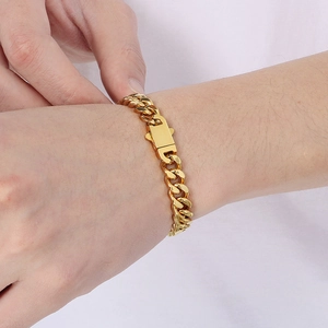 Close-up of gold-plated stainless steel Cuban link bracelet with square clasp on wrist