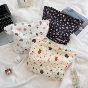 Detailed flat lay of quilted makeup bags with Christmas, dog, and floral patterns