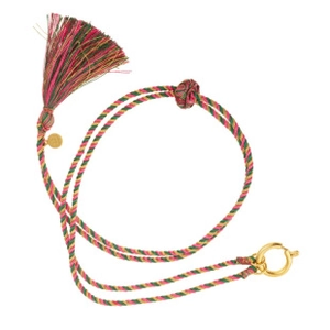 Détail macro du cordon tissé main multicolore avec franges et fermoir anneau en métal doré