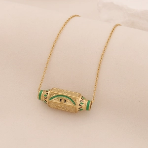Collana con pendente a barilotto dorato, occhio in smalto verde e dettagli in rilievo