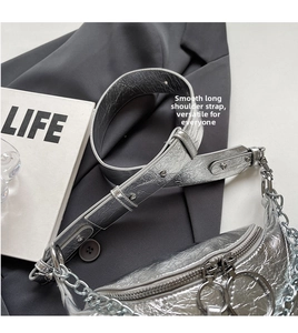 Detail of silver metallic textured crossbody bag with thick shoulder strap and chain link