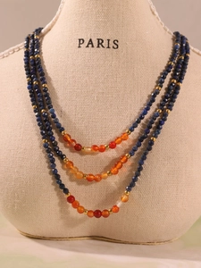 Vue macro détaillée du collier à trois rangs en perles de lapis et agate sur présentoir