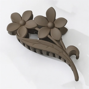 Detail of matte dark brown hair claw clip with double flower design on white background