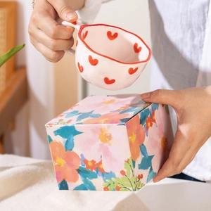 Handmade wavy ceramic heart mug with irregular red rim and floral gift box packaging