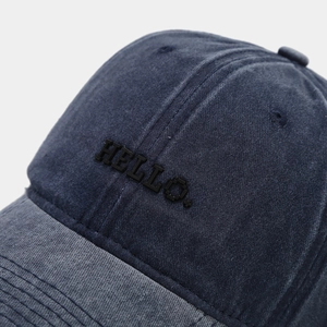 Close-up of HELLO embroidery on washed cotton vintage baseball cap texture