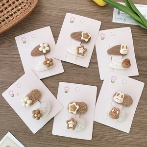 Detail of plush cartoon rabbit and star hair clips on elegant display cards