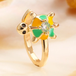 Macro shot of gold turtle ring with colorful enamel inlay and white zircon gemstone