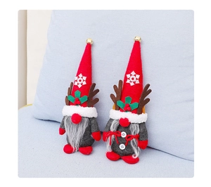 Detail of Christmas gnomes with reindeer antlers and red snowflake hats on blue fabric