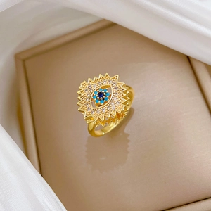 Macro detail of gold-plated spinning evil eye ring with blue stones and sparkling crystals