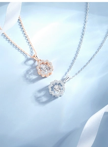 Detail of rose gold and silver sunflower necklaces with stones on blue fabric background