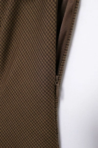 Detailed close-up of brown herringbone fabric with a seamless concealed zipper