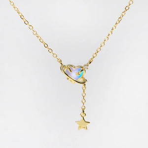 Detail of gold heart planet necklace with iridescent stone and dangling star charm