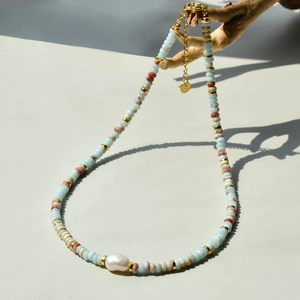 Fashion beaded necklace with baroque pearl and Shoushan stone on a natural wood branch