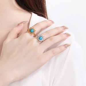 Macro detail of sunburst motif ring set with turquoise stone on model's hand